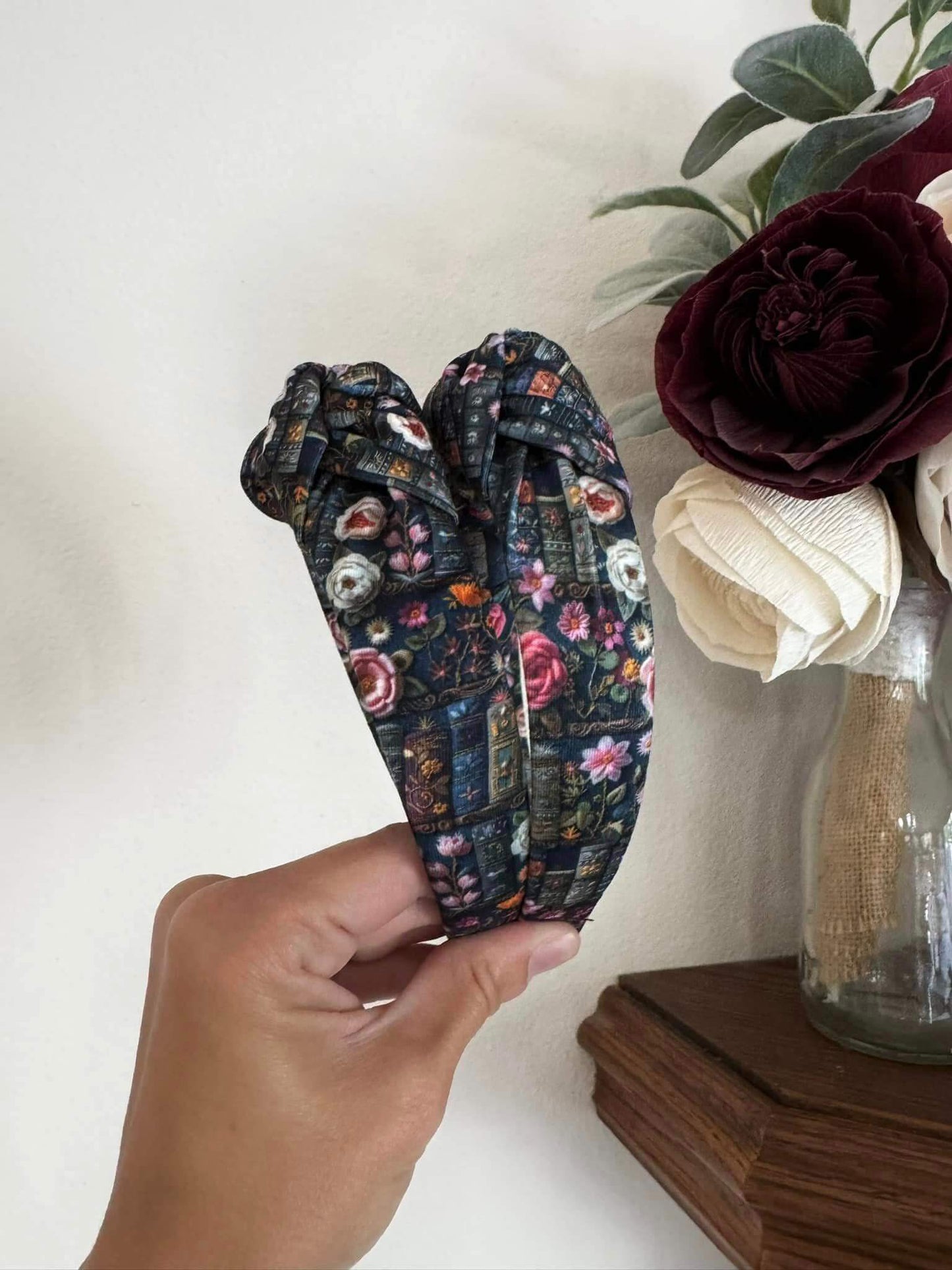 Enchanted Books Top Knot Headband, Step into a storybook world with our Enchanted Books Top Knot Headband. Featuring a darker floral print inspired by classic library tales, this low top knot headband adds a whimsical, Beauty and the Beast–inspired charm