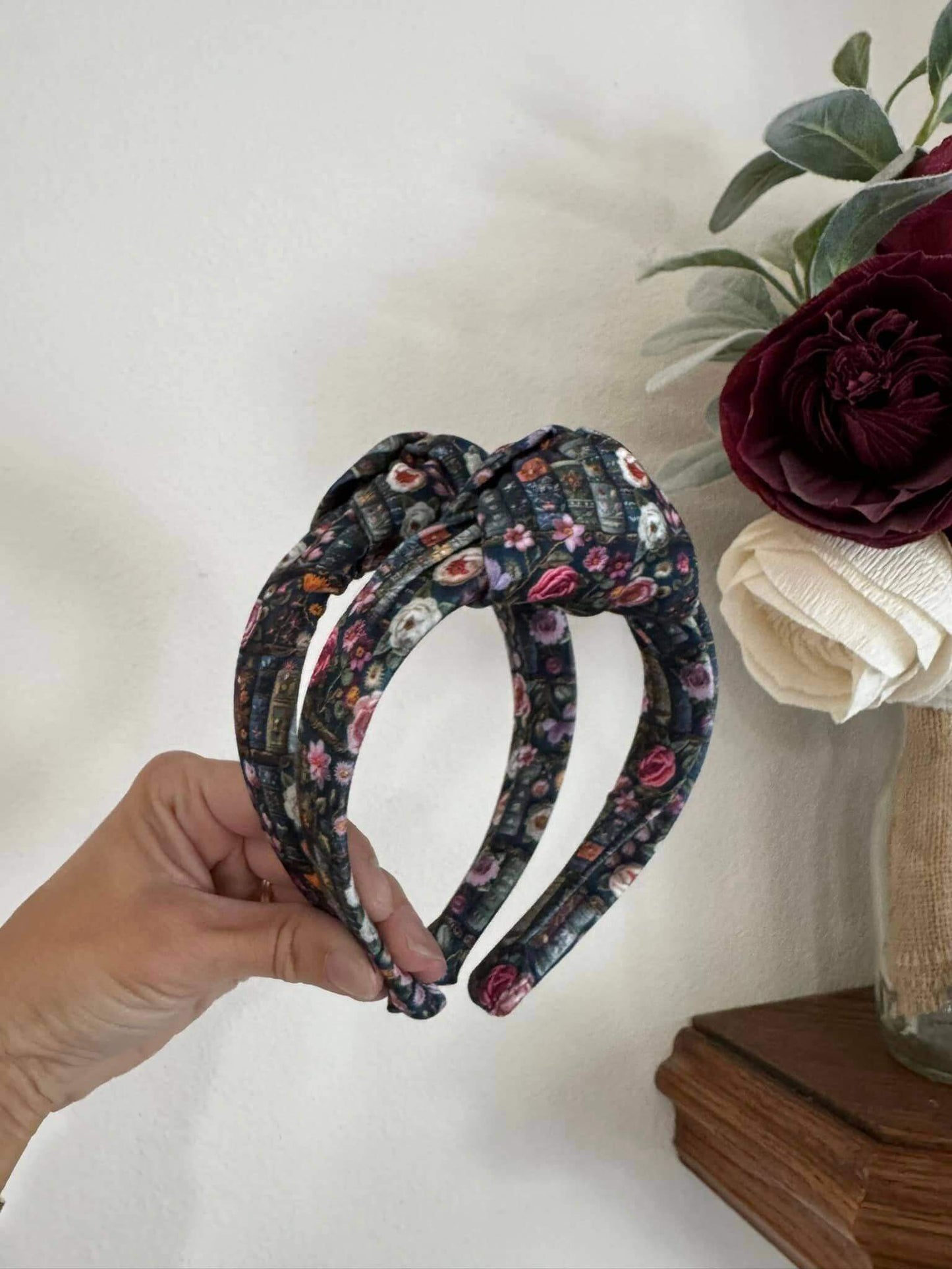 Enchanted Books Top Knot Headband, Step into a storybook world with our Enchanted Books Top Knot Headband. Featuring a darker floral print inspired by classic library tales, this low top knot headband adds a whimsical, Beauty and the Beast–inspired charm