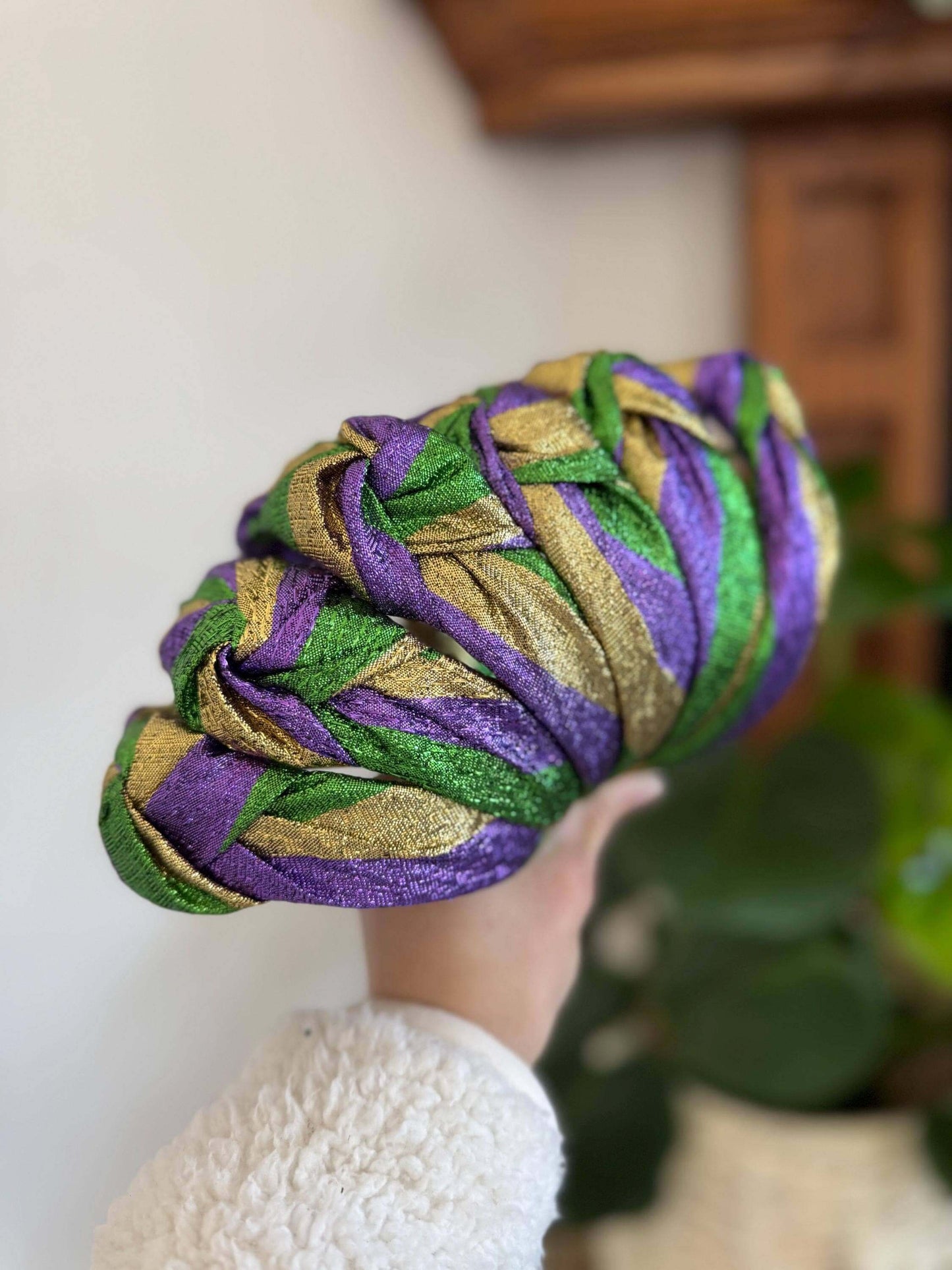 The Mardi Gras New Orleans Headband, Celebrate in style with The Mardi Gras New Orleans Headband, featuring vibrant metallic tricolor accents perfect for any festival or party. This playful top knot design adds a fun, festive touch to your outfit, making