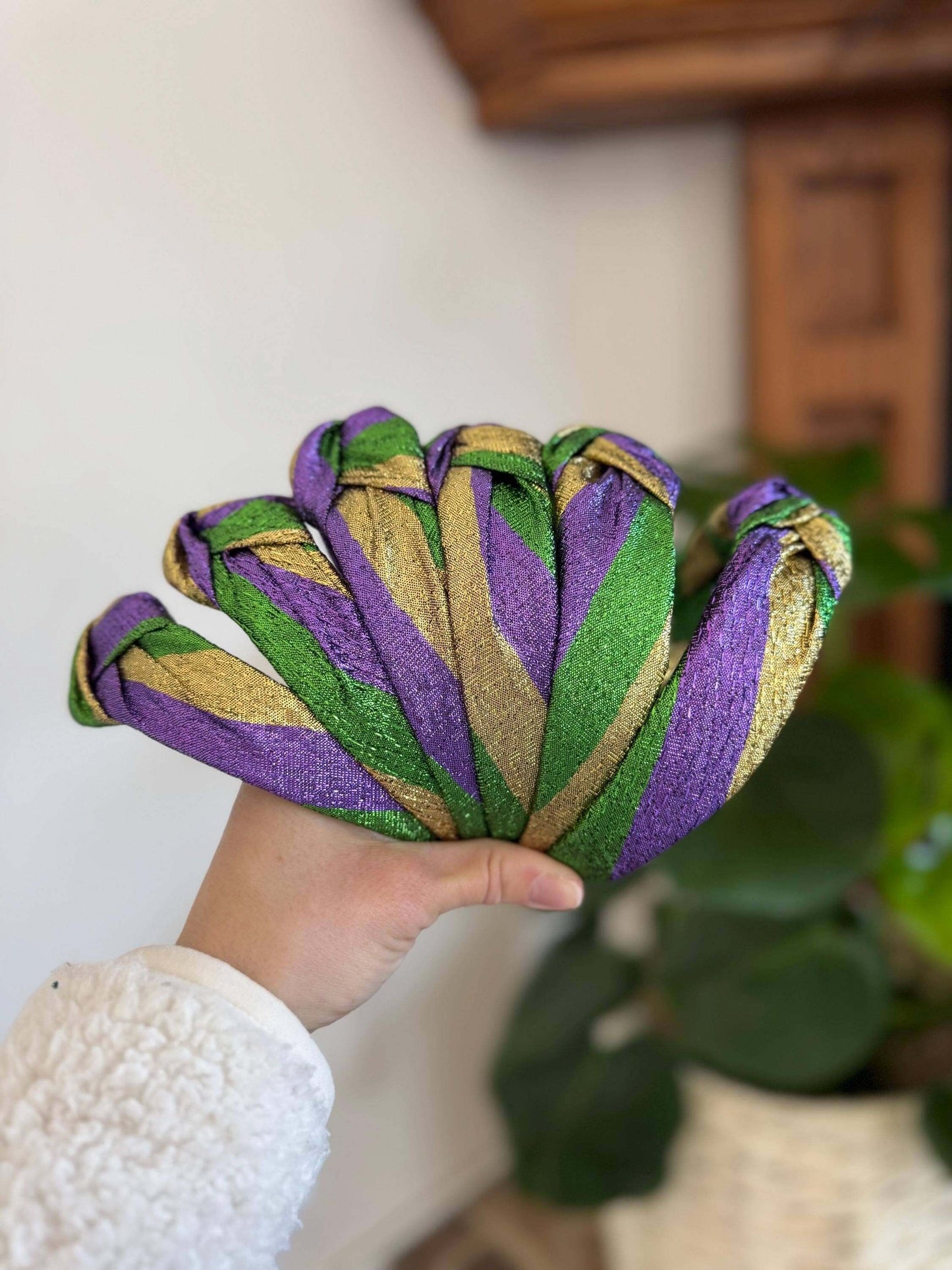 The Mardi Gras New Orleans Headband, Celebrate in style with The Mardi Gras New Orleans Headband, featuring vibrant metallic tricolor accents perfect for any festival or party. This playful top knot design adds a fun, festive touch to your outfit, making