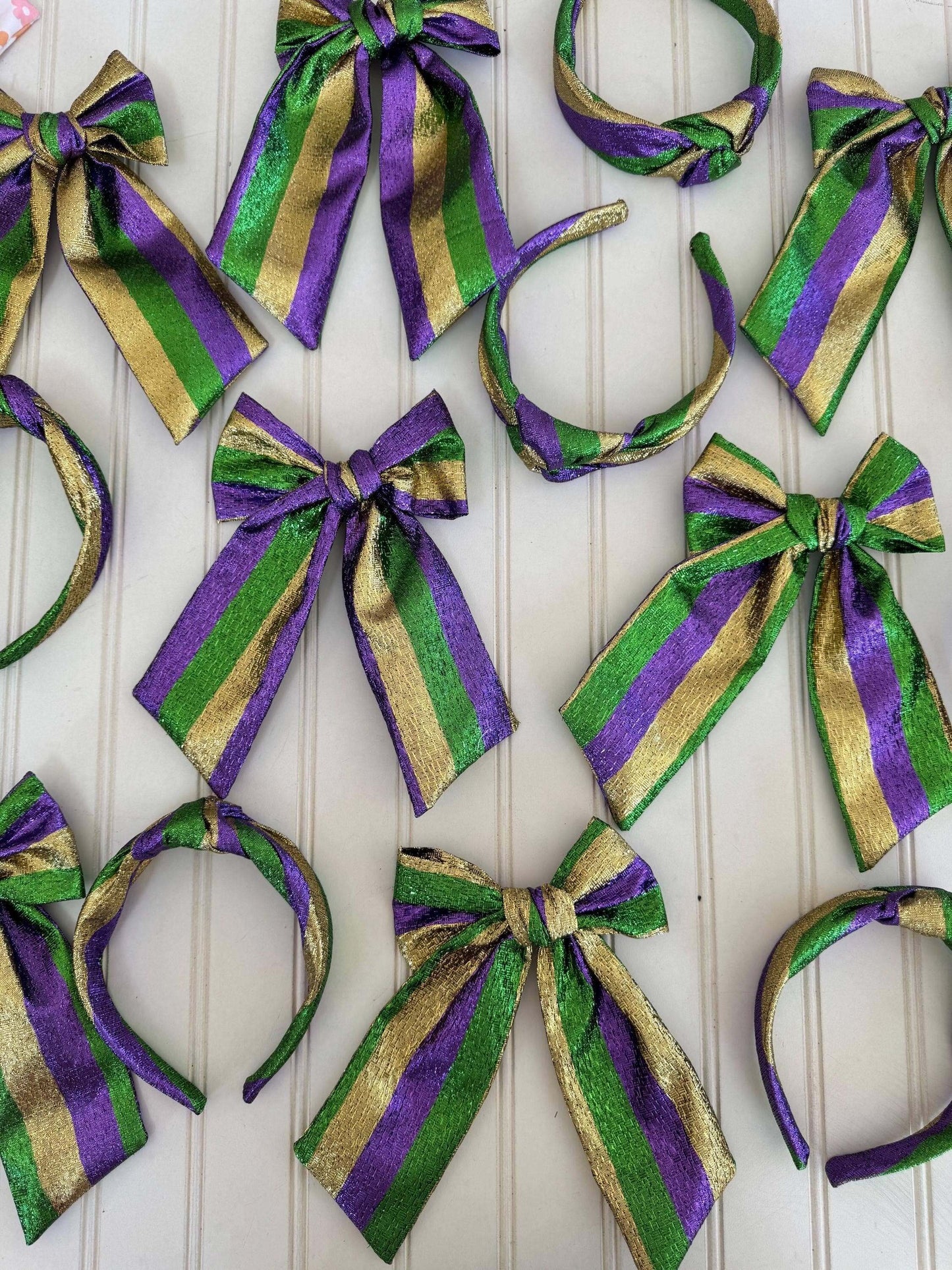 The Mardi Gras New Orleans Headband, Celebrate in style with The Mardi Gras New Orleans Headband, featuring vibrant metallic tricolor accents perfect for any festival or party. This playful top knot design adds a fun, festive touch to your outfit, making