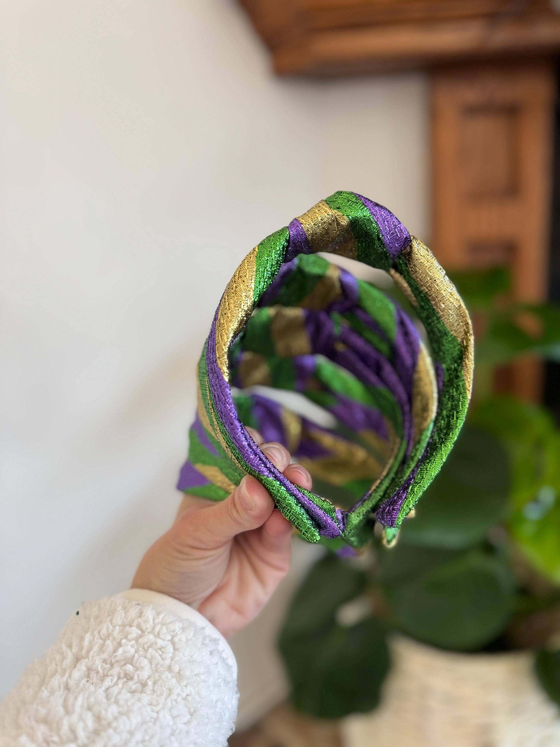 The Mardi Gras New Orleans Headband, Celebrate in style with The Mardi Gras New Orleans Headband, featuring vibrant metallic tricolor accents perfect for any festival or party. This playful top knot design adds a fun, festive touch to your outfit, making